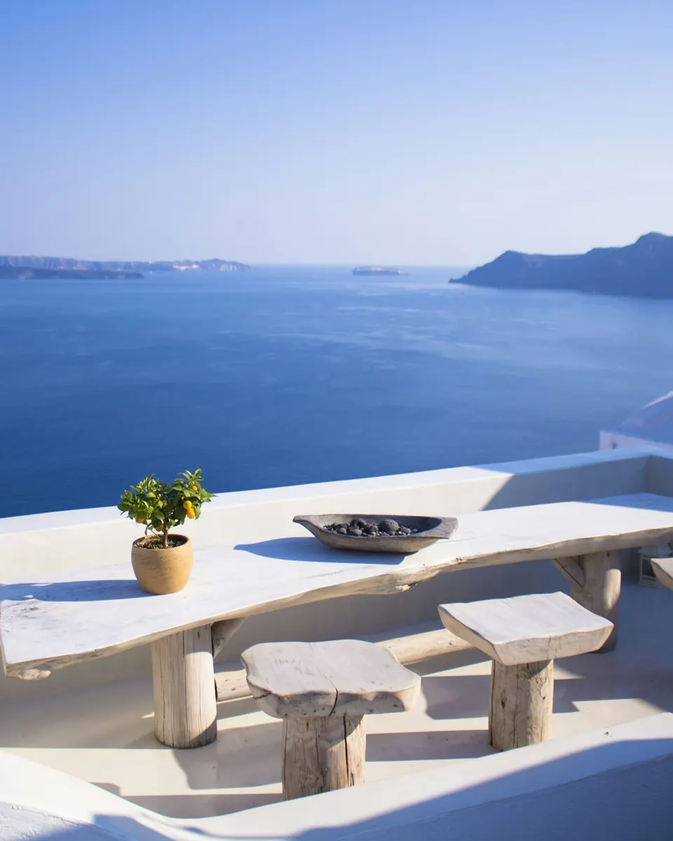 A whitewashed terrace above the sea, its long stone table and benches looking out over the water.